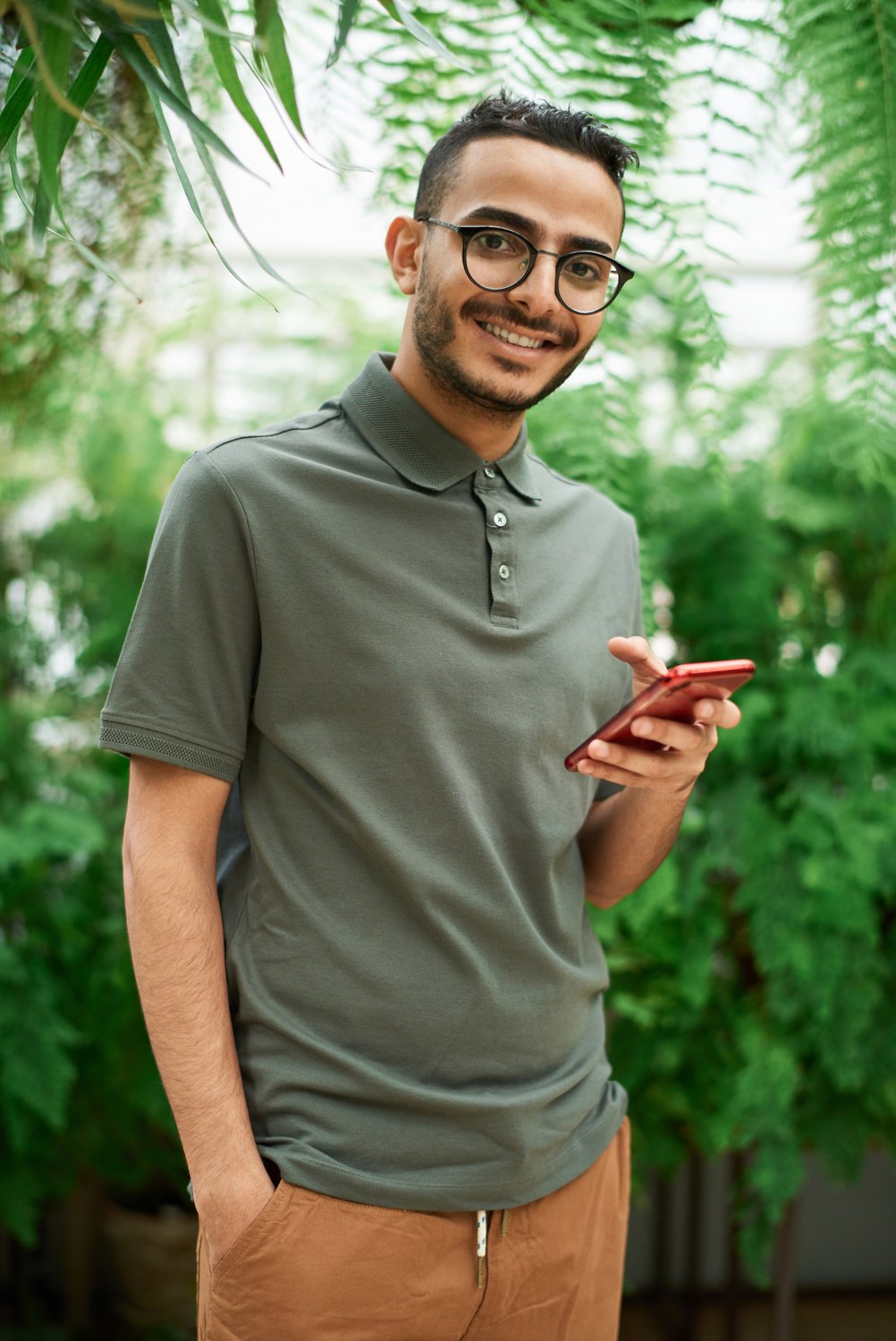 Man in Gray Polo Shirt Holding Red Smartphone